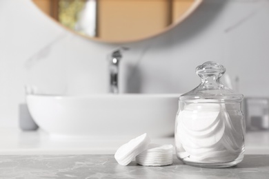 Cotton pads on light grey marble table in bathroom