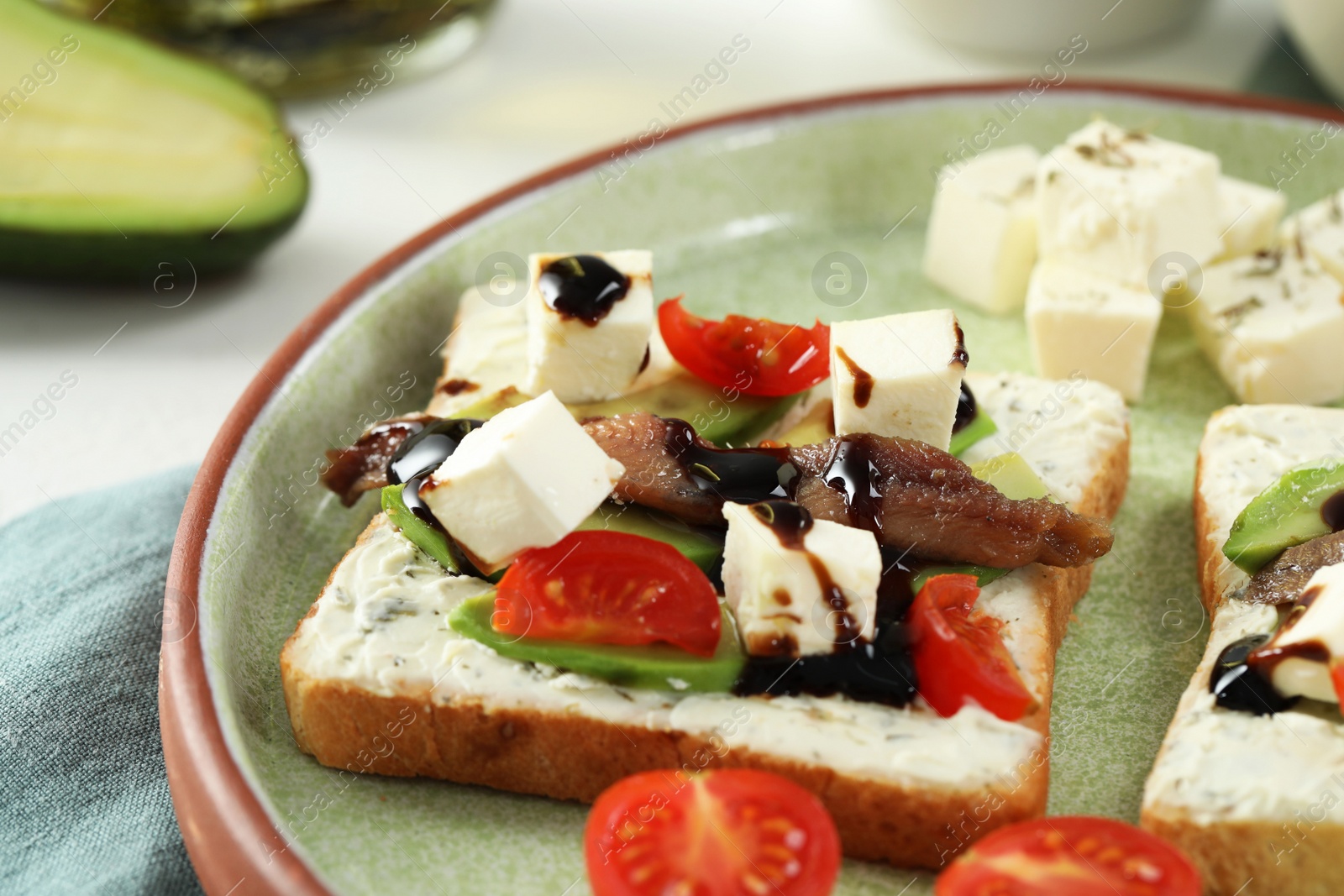 Photo of Delicious sandwiches with anchovies, cheese and tomato on white table, closeup