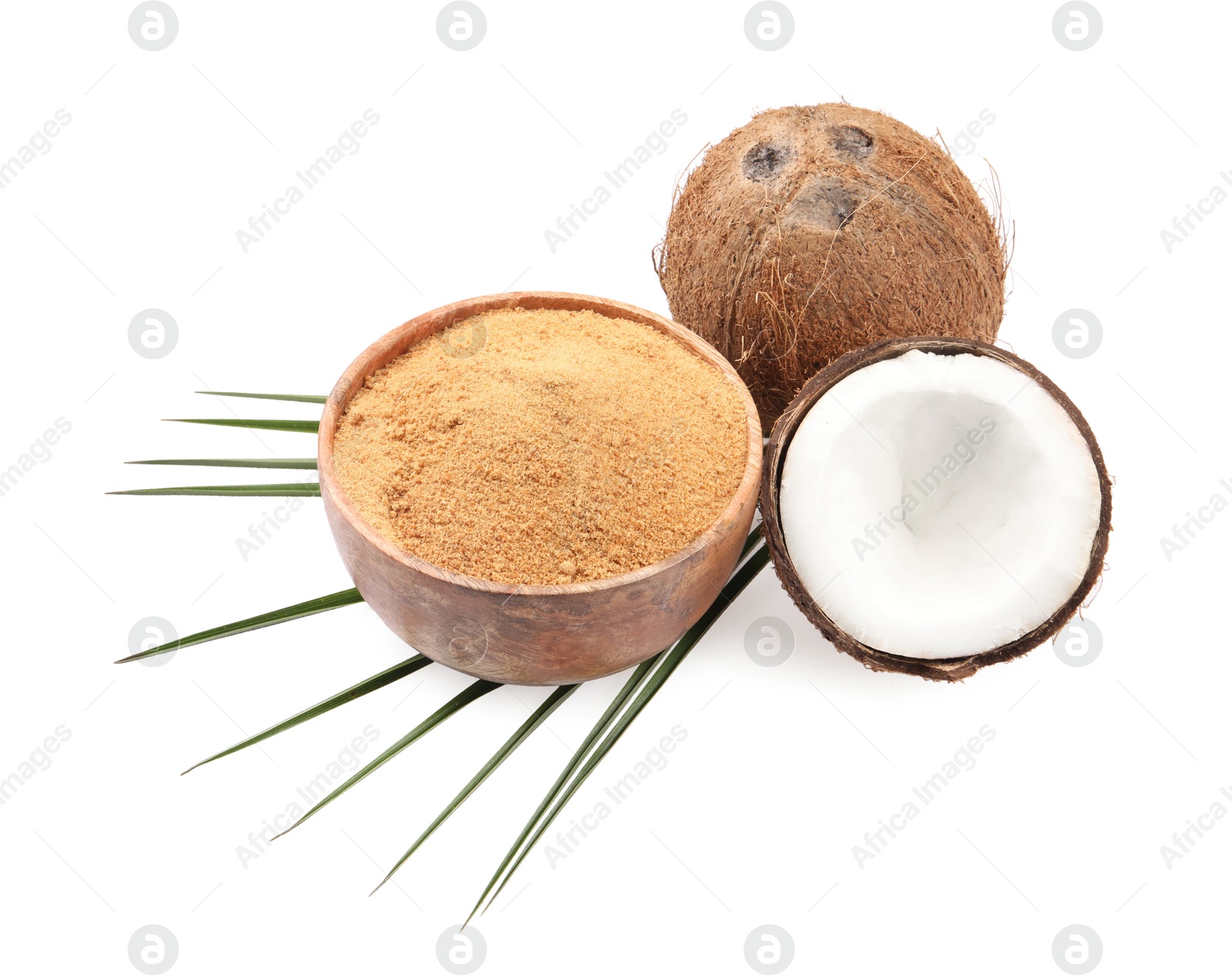 Photo of Coconut sugar in bowl, fruits and palm leaf isolated on white