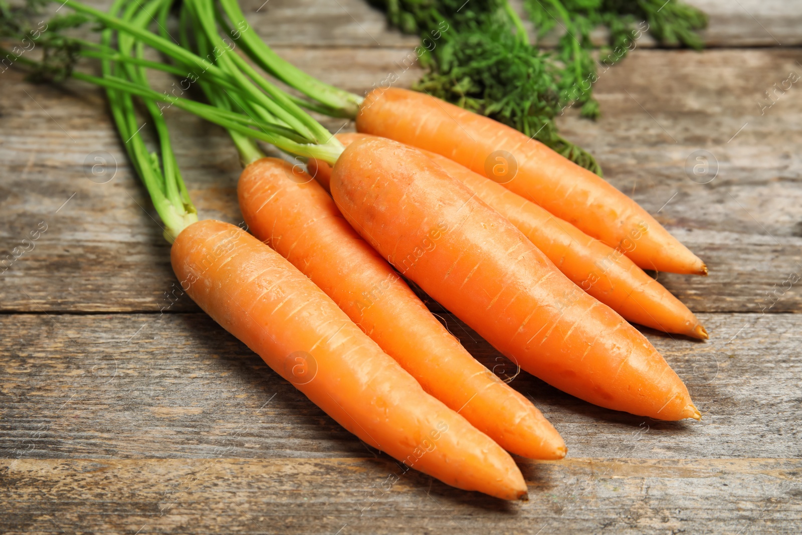 Photo of Ripe carrots on wooden background. Healthy diet