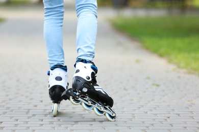 Photo of Woman roller skating on city street, closeup of legs