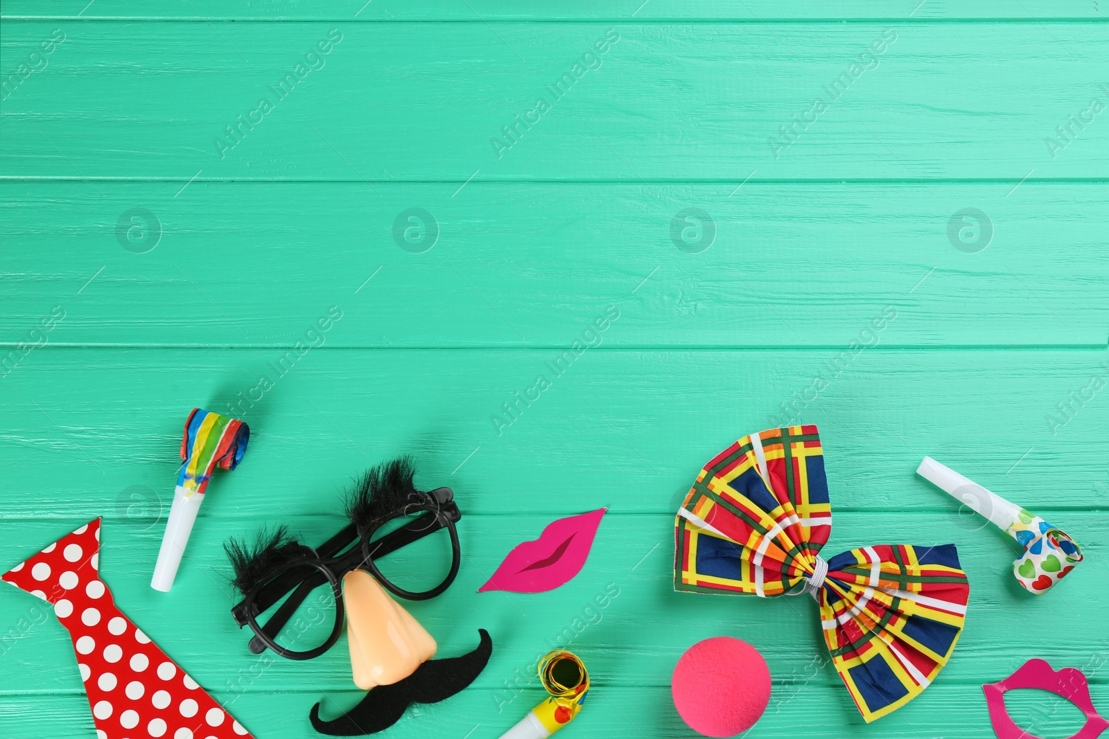 Photo of Flat lay composition with clown's items on turquoise wooden table, space for text