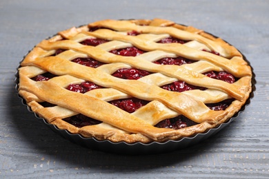 Delicious fresh cherry pie on light grey wooden table, closeup