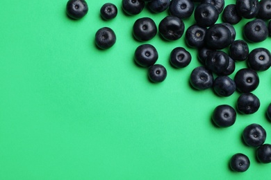 Photo of Fresh acai berries on green background, flat lay. Space for text