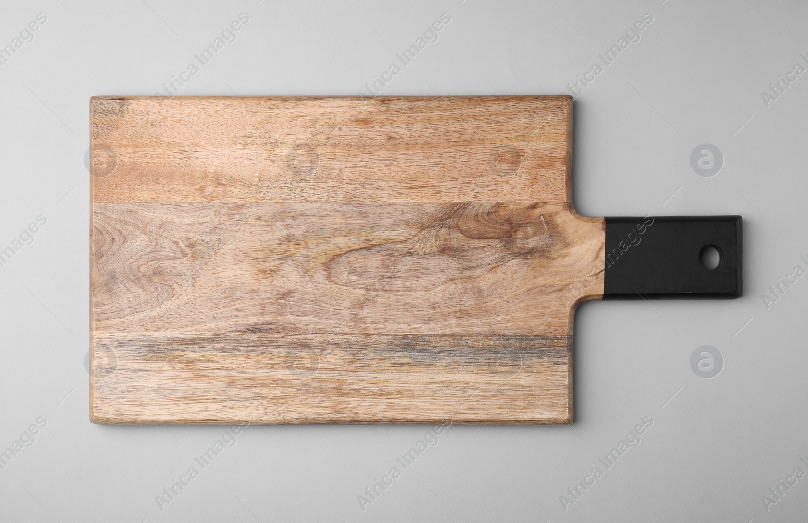 Photo of One wooden board on light grey background, top view