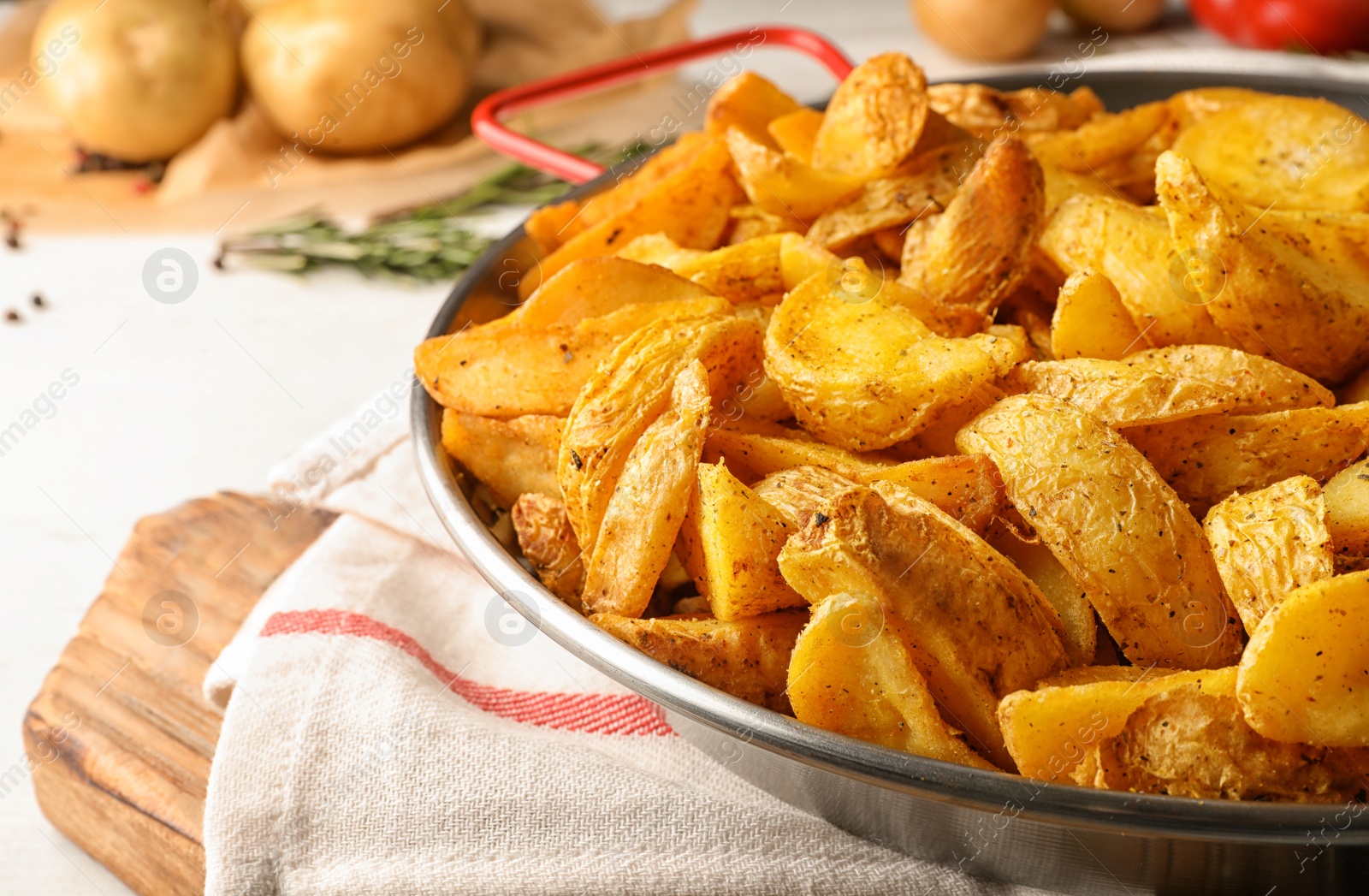 Photo of Dish of delicious oven baked potatoes on table, closeup