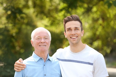 Man with elderly father outdoors on sunny day