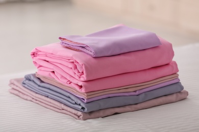 Photo of Clean color folded linens on bed indoors