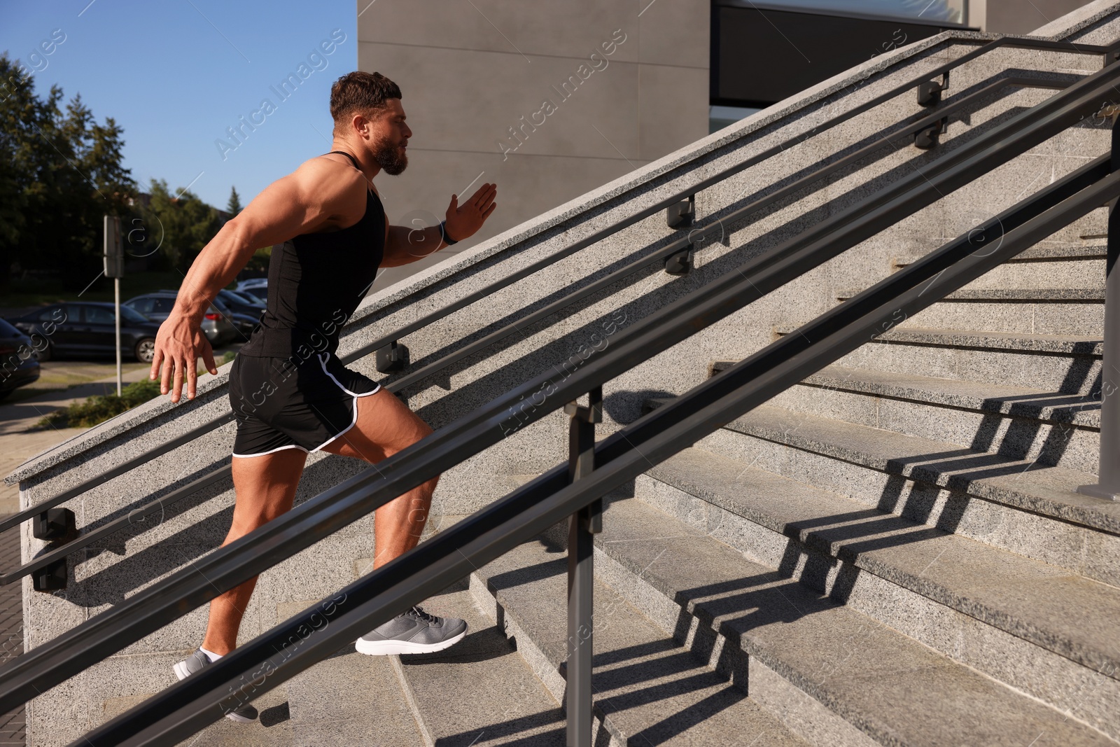 Photo of Man running up stairs outdoors on sunny day