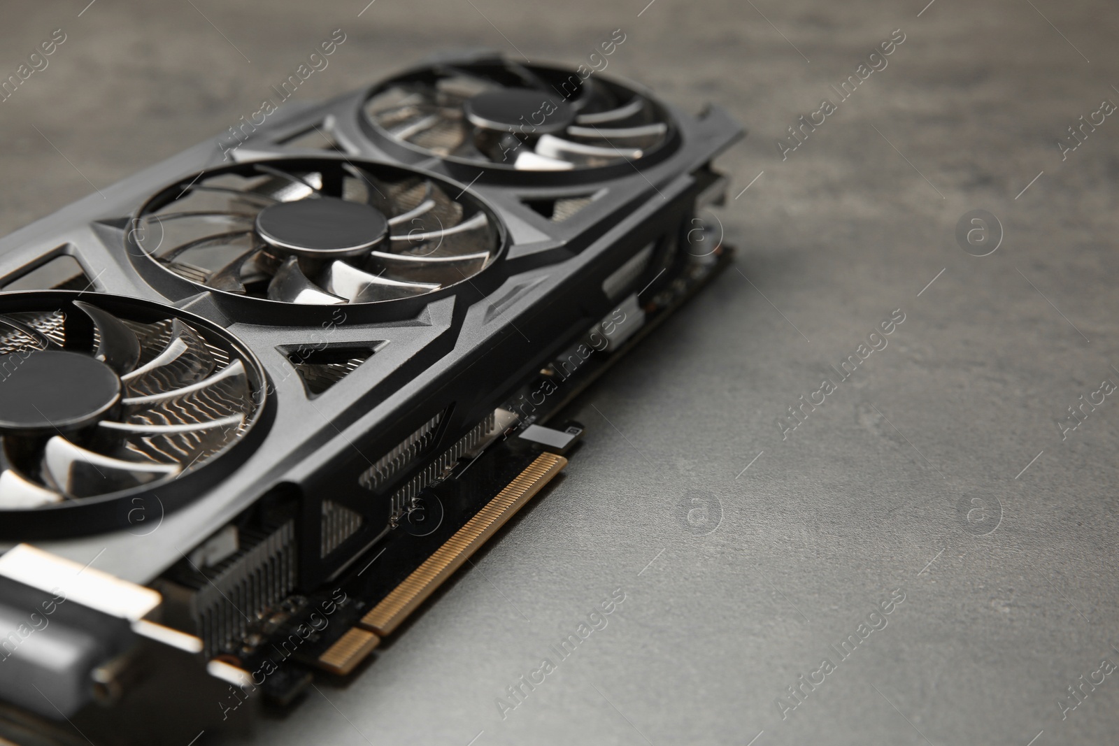 Photo of One computer graphics card on grey textured table, closeup. Space for text