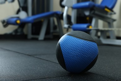 Photo of Blue medicine ball on floor in gym, space for text