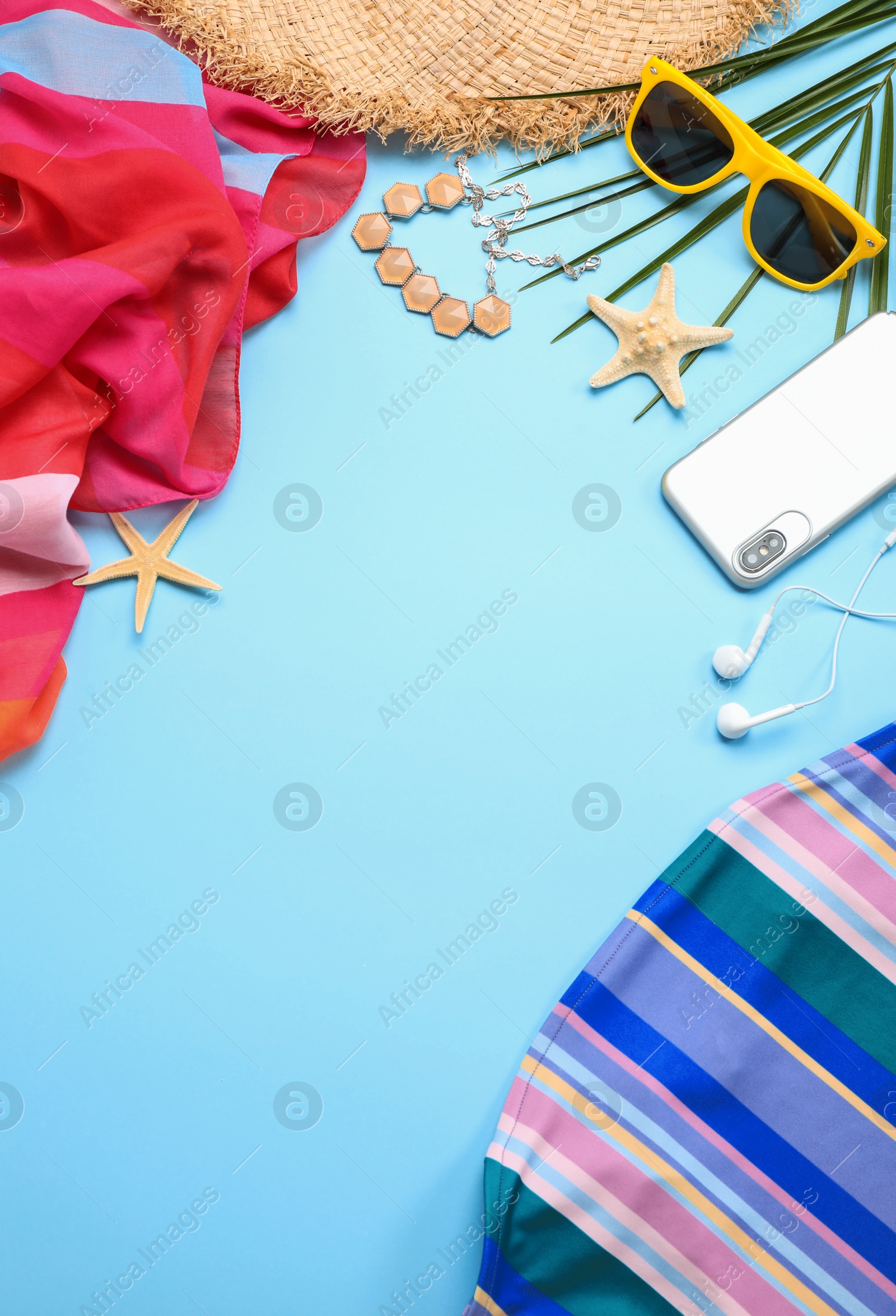 Photo of Flat lay composition with beach accessories on light blue background, space for text