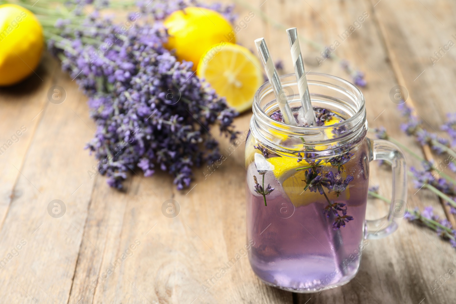 Photo of Fresh delicious lemonade with lavender in masson jar on wooden table. Space for text