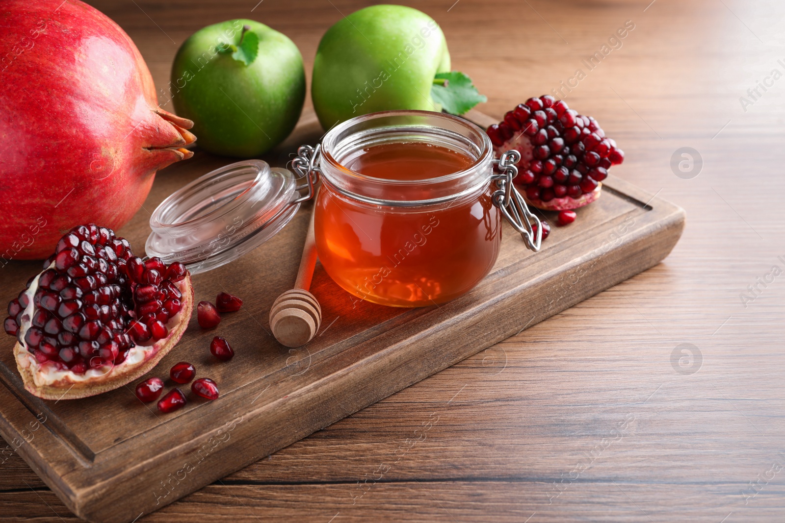 Photo of Honey, pomegranate and apples on wooden table. Rosh Hashana holiday