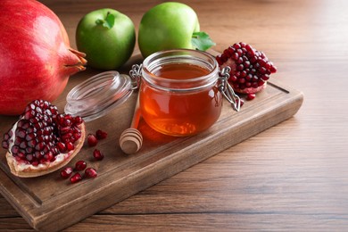 Honey, pomegranate and apples on wooden table. Rosh Hashana holiday