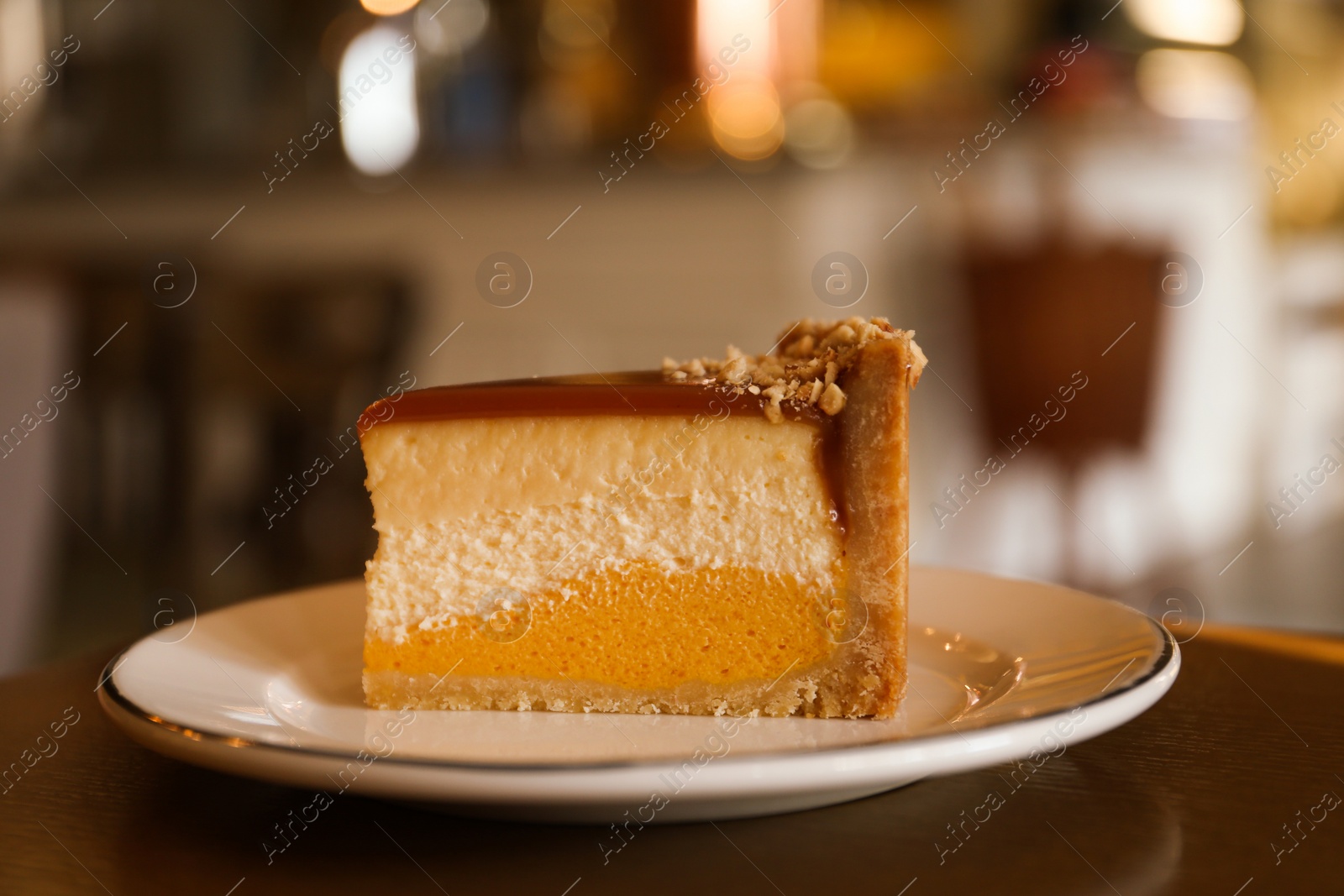 Photo of Piece of delicious cheesecake on table in cafe, closeup