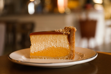 Photo of Piece of delicious cheesecake on table in cafe, closeup