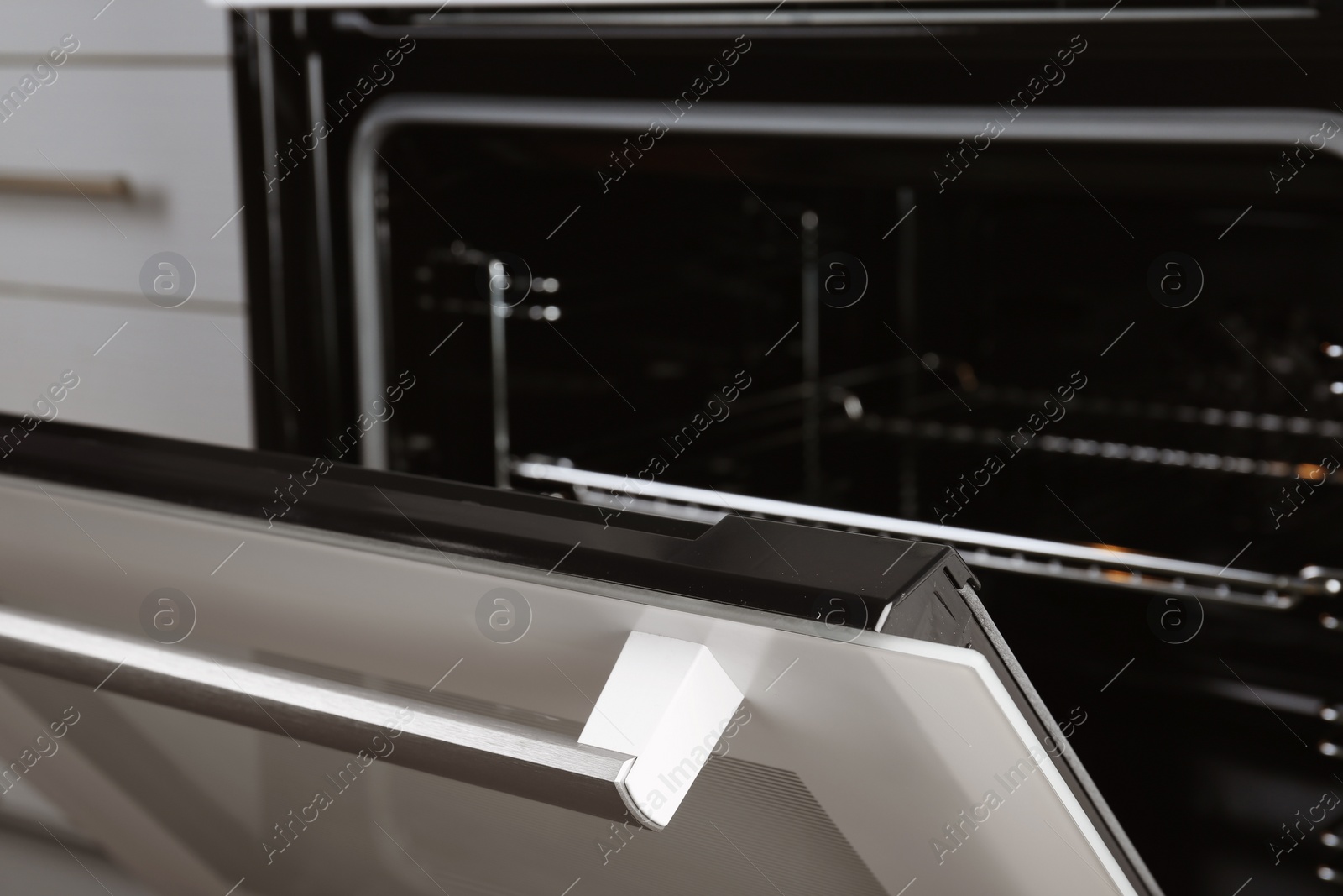 Photo of Open empty electric oven with rack, closeup