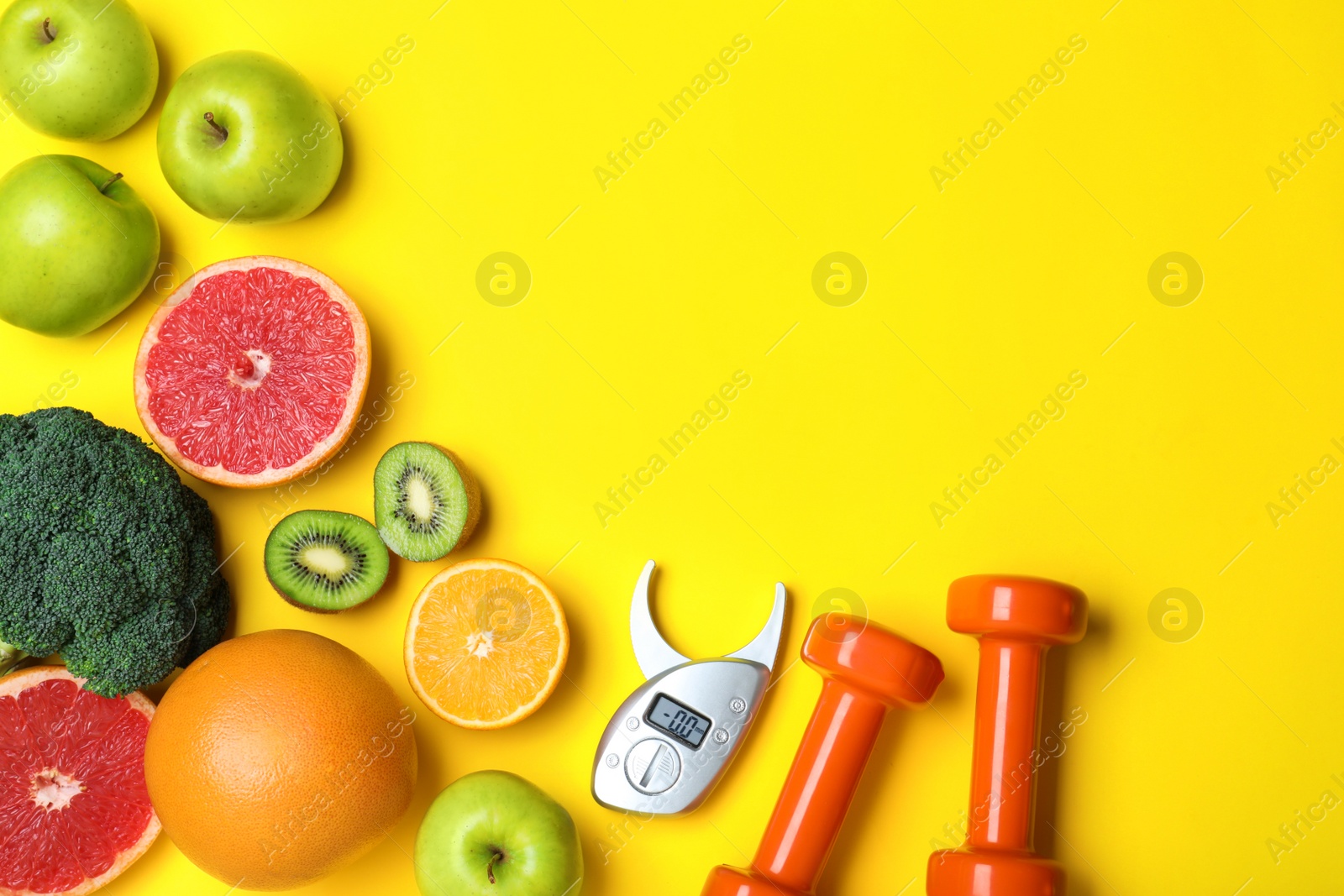 Photo of Fruits, vegetables, dumbbells and digital caliper on yellow background, flat lay with space for text. Visiting nutritionist