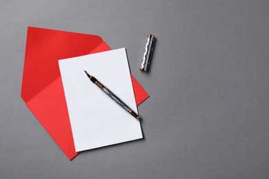 Blank sheet of paper, letter envelope and pen on grey background, top view. Space for text