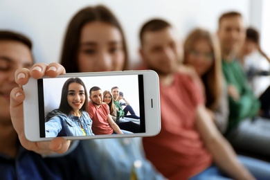 Happy friends taking selfie indoors