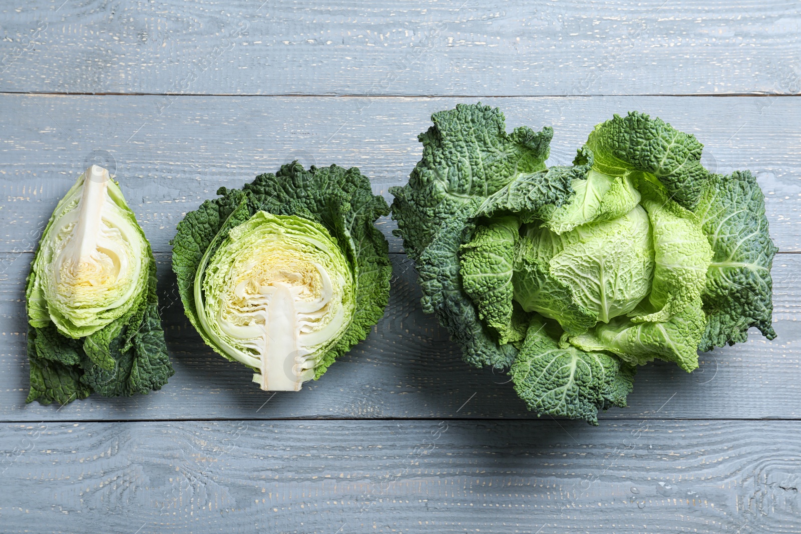 Photo of Flat lay composition with fresh green savoy cabbages on grey wooden table