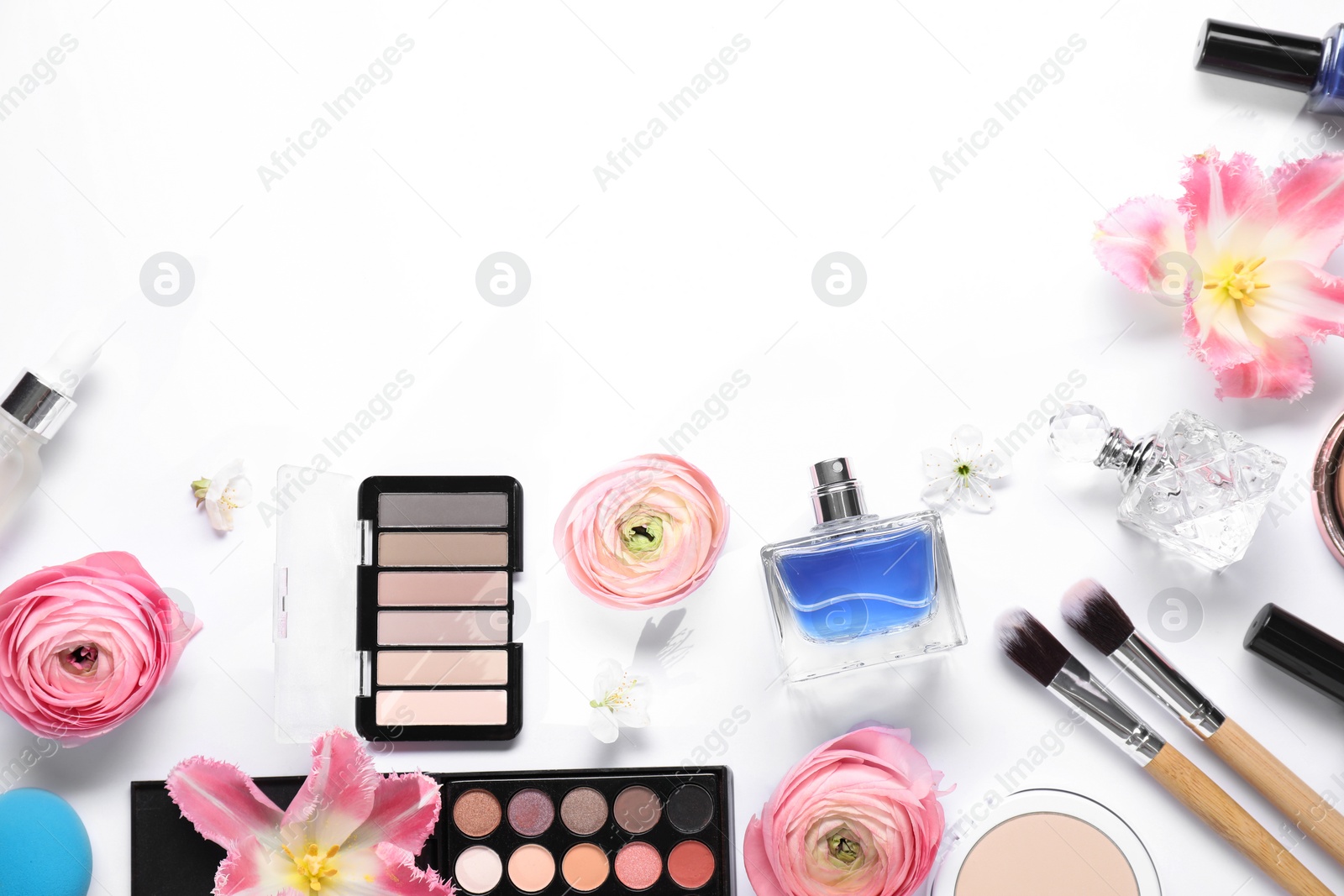 Photo of Flat lay composition with different makeup products and beautiful spring flowers on white background, space for text