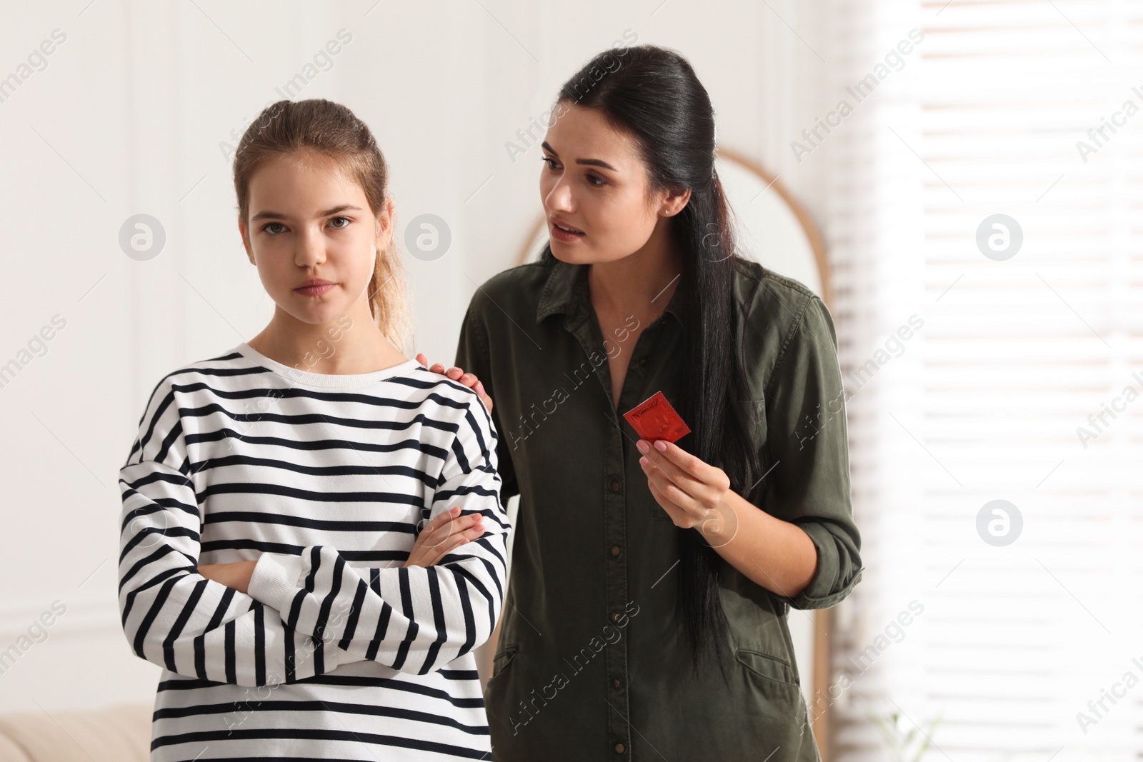 Photo of Mother talking with her teenage daughter about contraception at home. Sex education concept