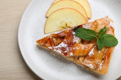 Photo of Slice of traditional apple pie on wooden table, top view