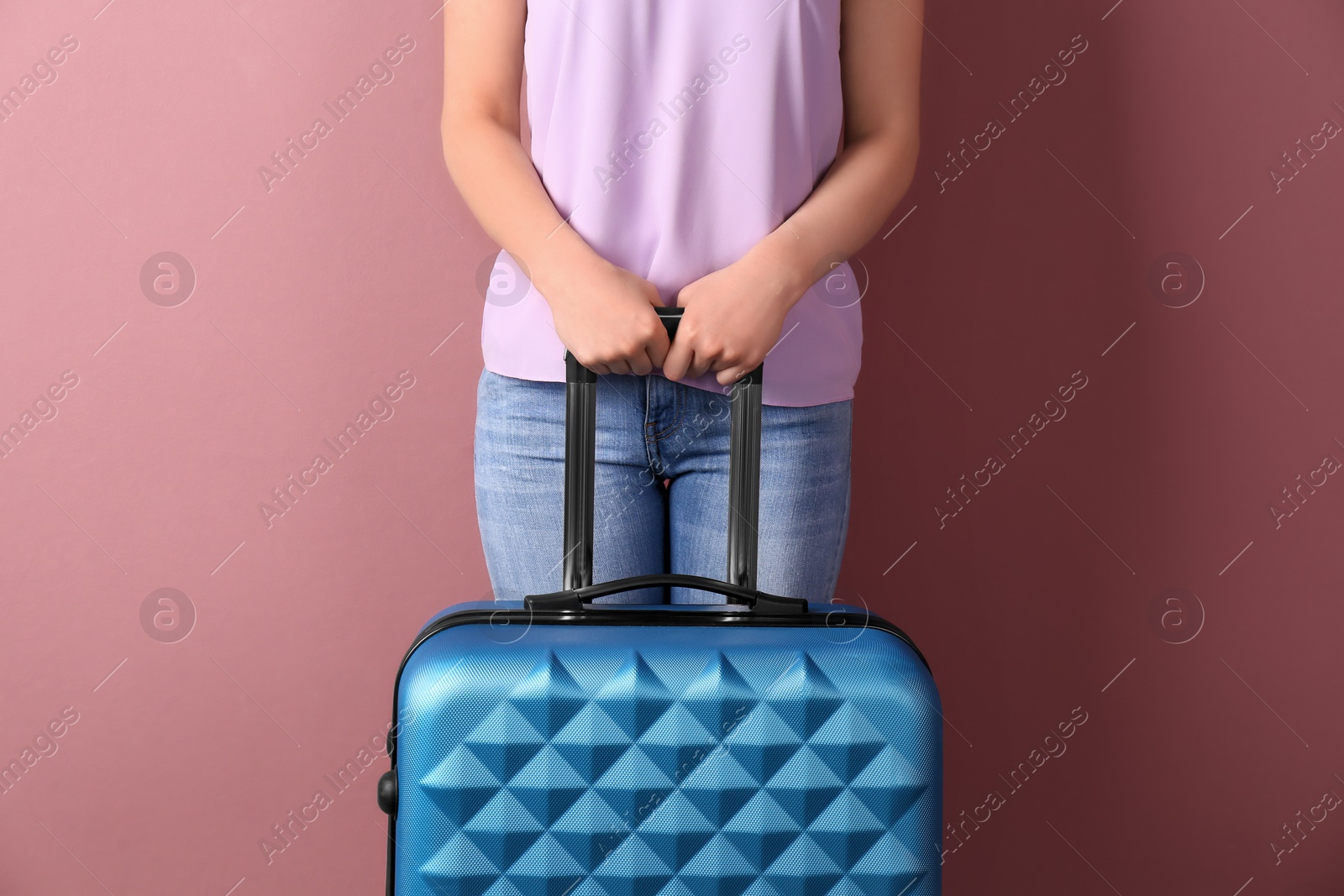 Photo of Young woman with suitcase on color background