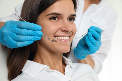 Photo of Dentist examining patient's teeth in modern clinic, closeup. Cosmetic dentistry