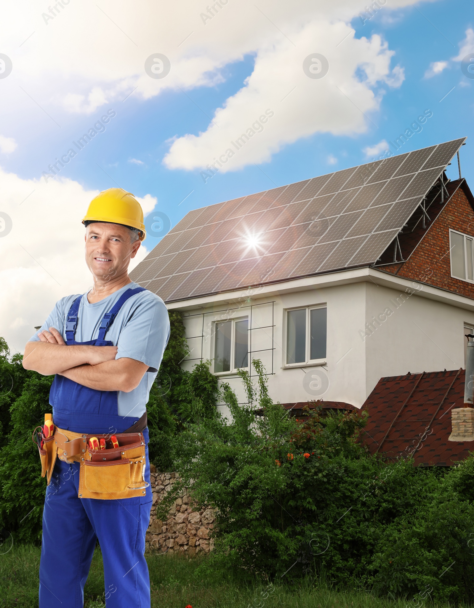 Image of Engineer near house with installed solar panels. Alternative energy source