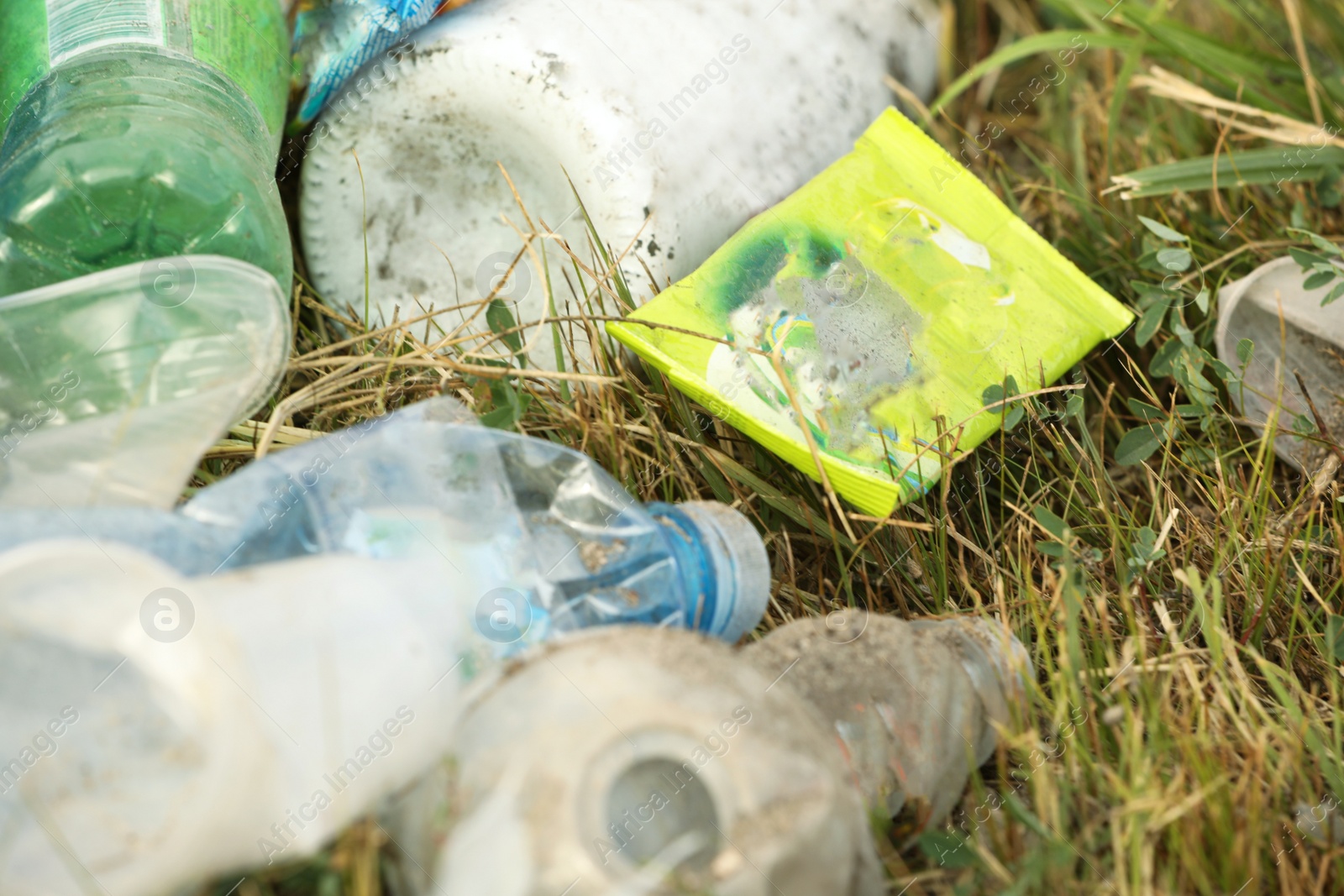 Photo of Garbage scattered on grass, closeup. Environment pollution problem