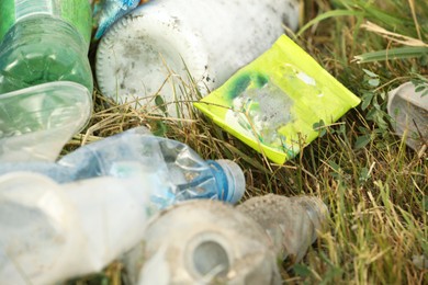 Photo of Garbage scattered on grass, closeup. Environment pollution problem