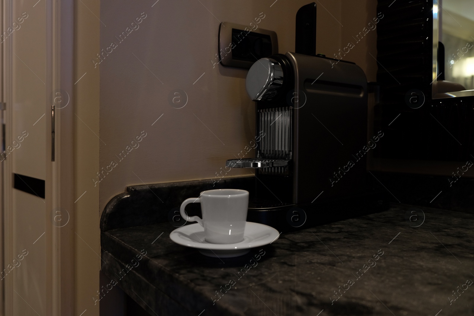 Photo of White cup near coffee machine on table