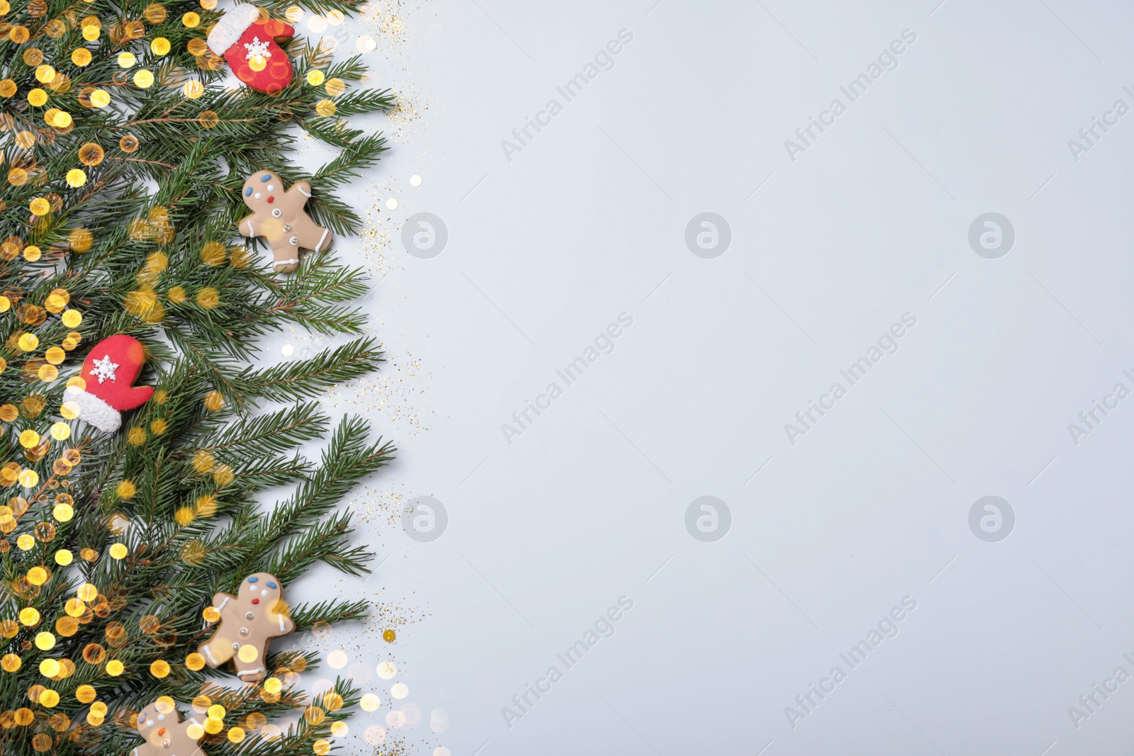 Photo of Christmas greeting card with space for text. Flat lay composition of fir tree branches and festive decor on white background
