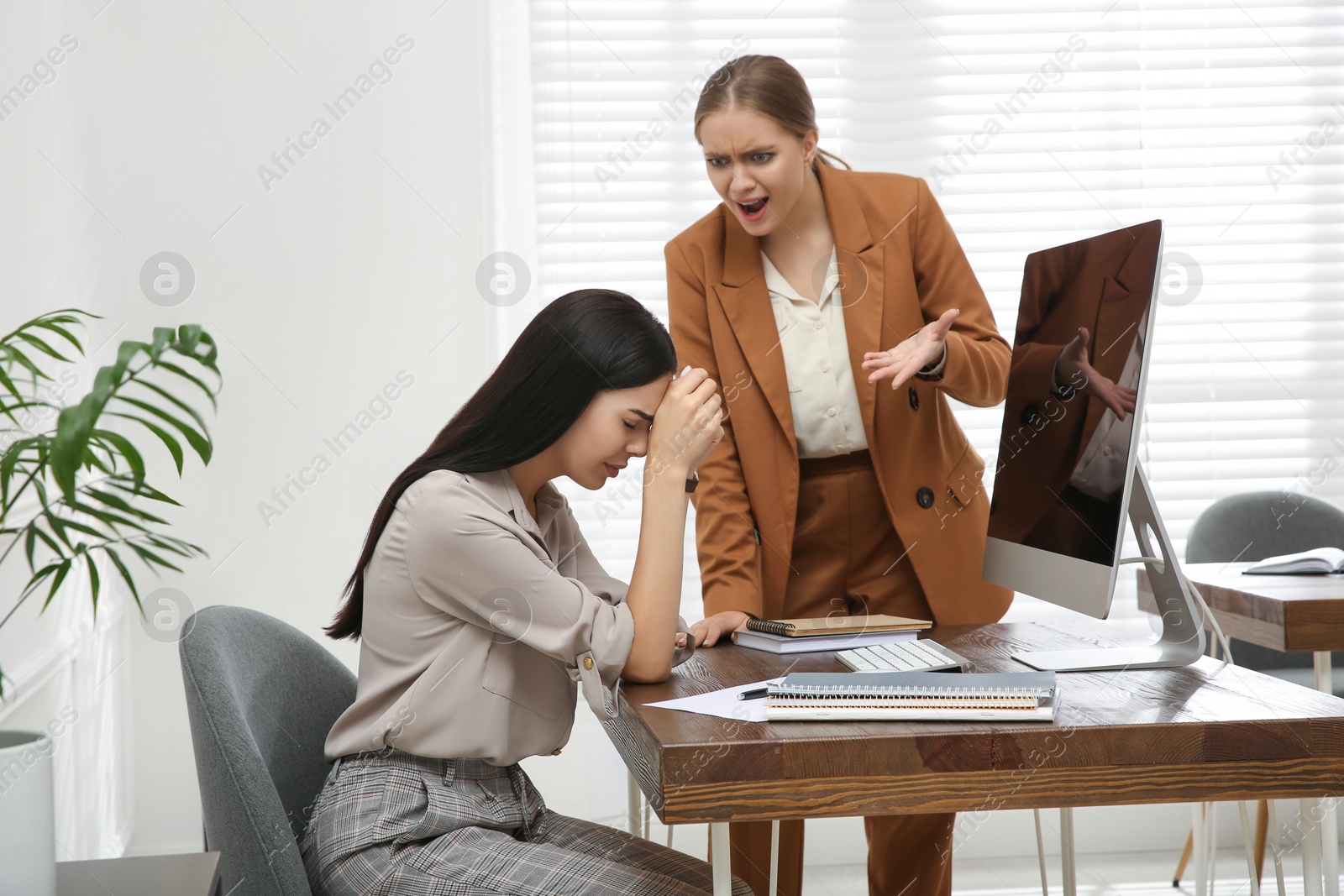 Photo of Boss screaming at employee in office. Toxic work environment