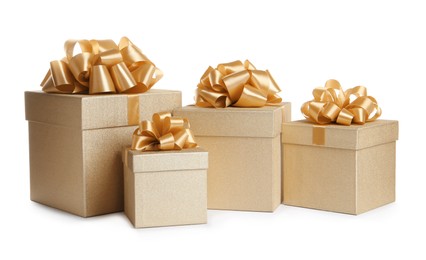 Photo of Golden gift boxes with satin bows on white background