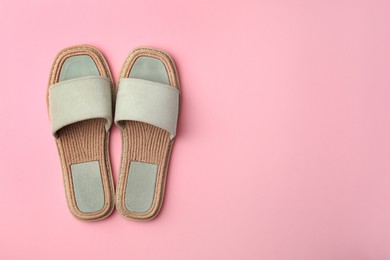 Photo of Pair of new slippers on pink background, flat lay. Space for text