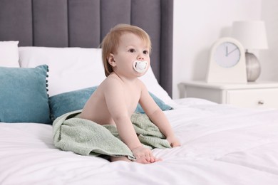 Cute little baby with towel after bathing on bed, space for text