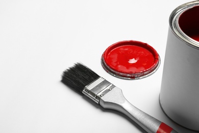 Photo of Paint can and brush on white background, space for text