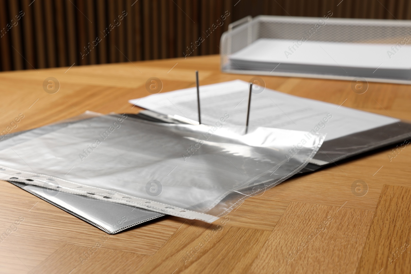 Photo of File folder with punched pockets on wooden table, closeup