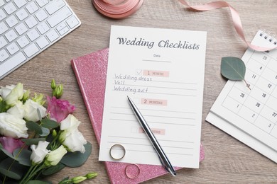 Flat lay composition with Wedding Checklist and planner on wooden table