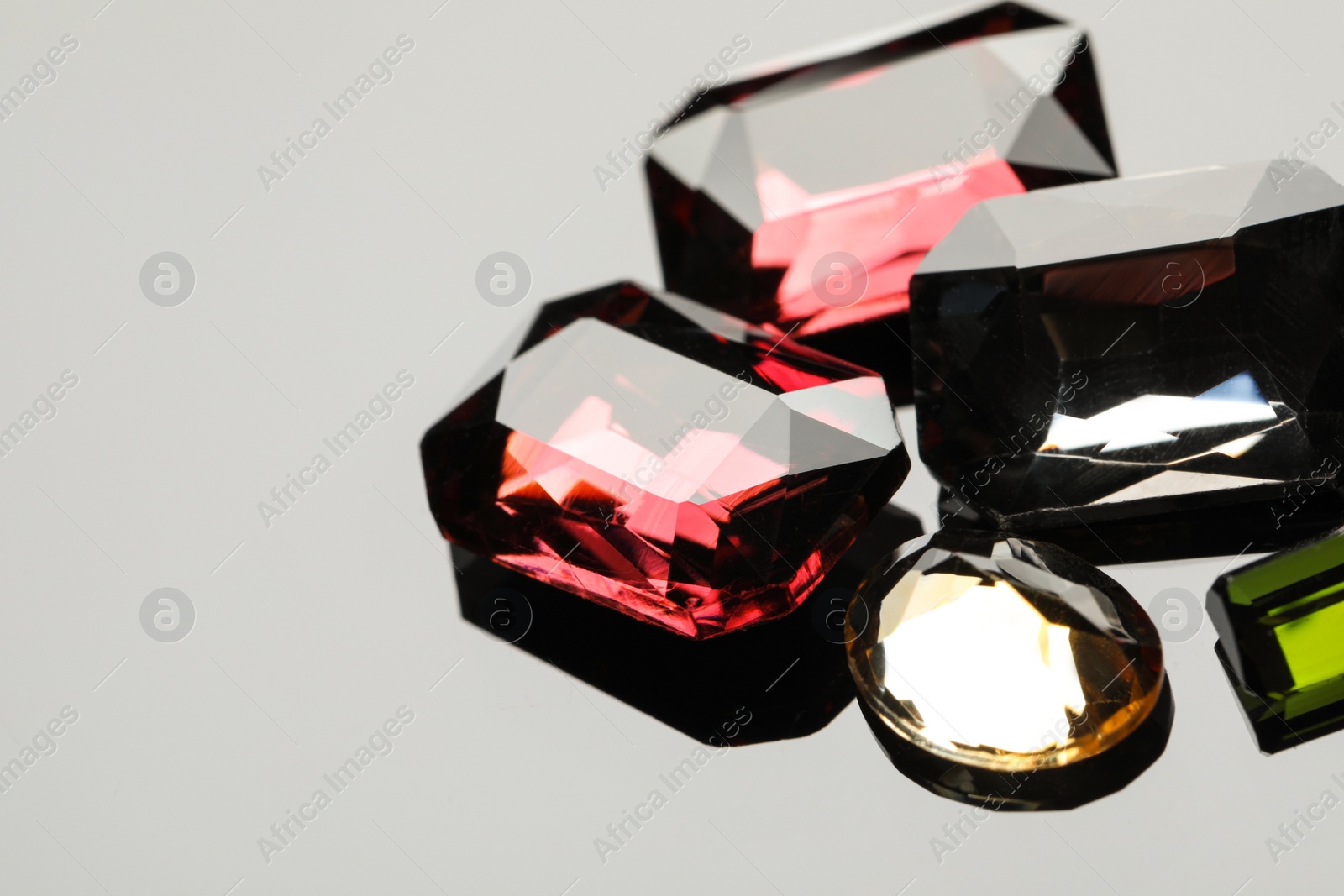 Photo of Beautiful gemstones for jewelry on light grey background, closeup