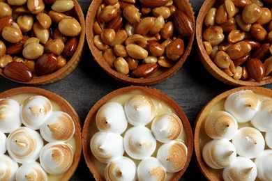 Photo of Many different tartlets on dark grey table, flat lay. Tasty dessert