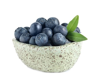 Bowl of fresh raw blueberries with leaves isolated on white