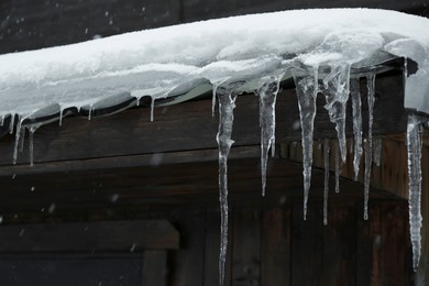 Photo of House with icicles on roof. Winter season