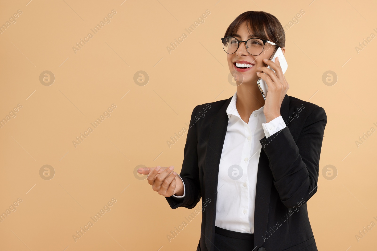 Photo of Happy secretary talking on smartphone against beige background. Space for text