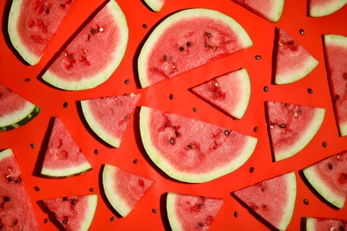 Photo of Watermelon slices on red background, flat lay