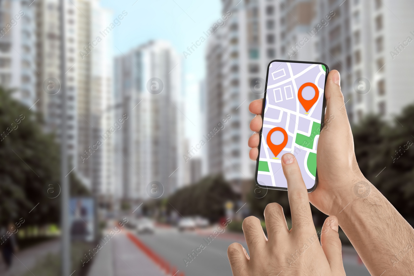 Image of Man searching location with smartphone in city, closeup. Space for text 